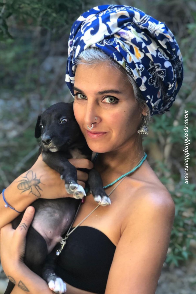 A gray haired woman with a puppy in her hands