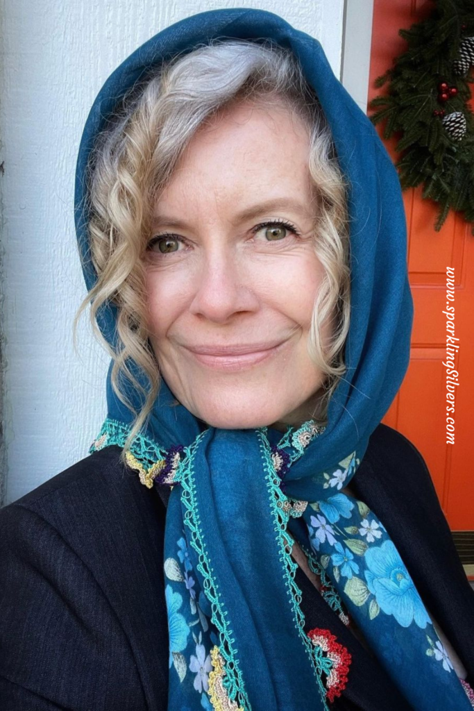 A blue scarf on a white woman with gray hair