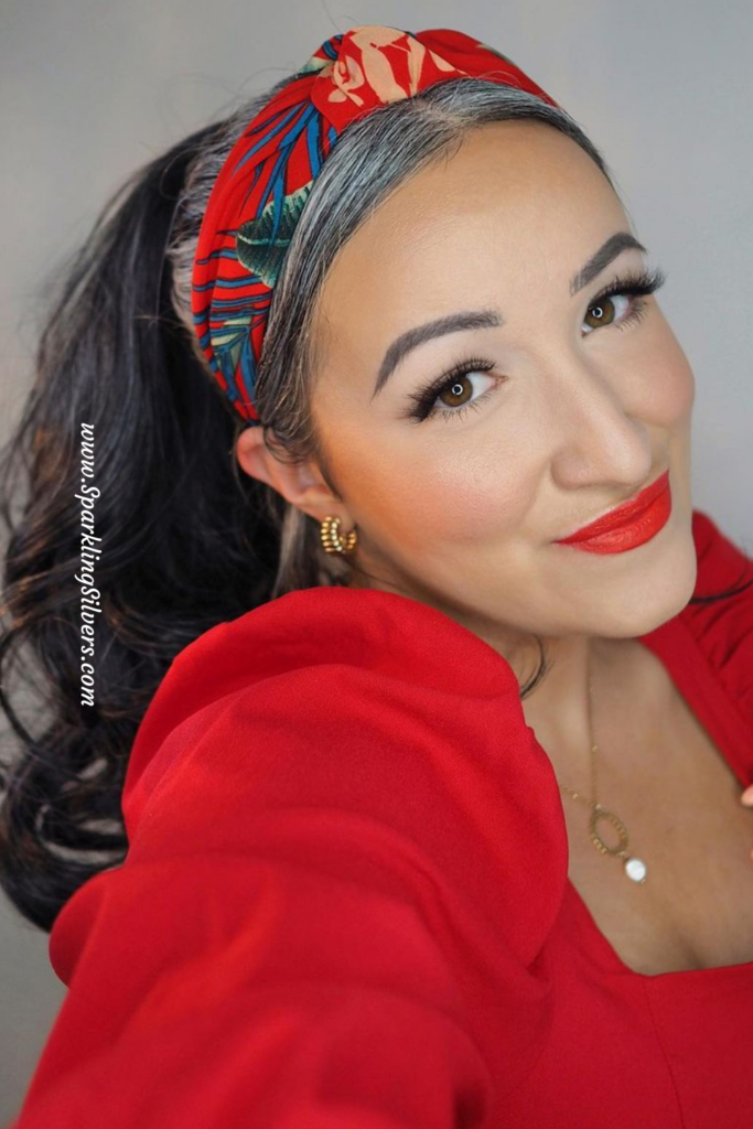 grey haired woman with red lipstick and red dress