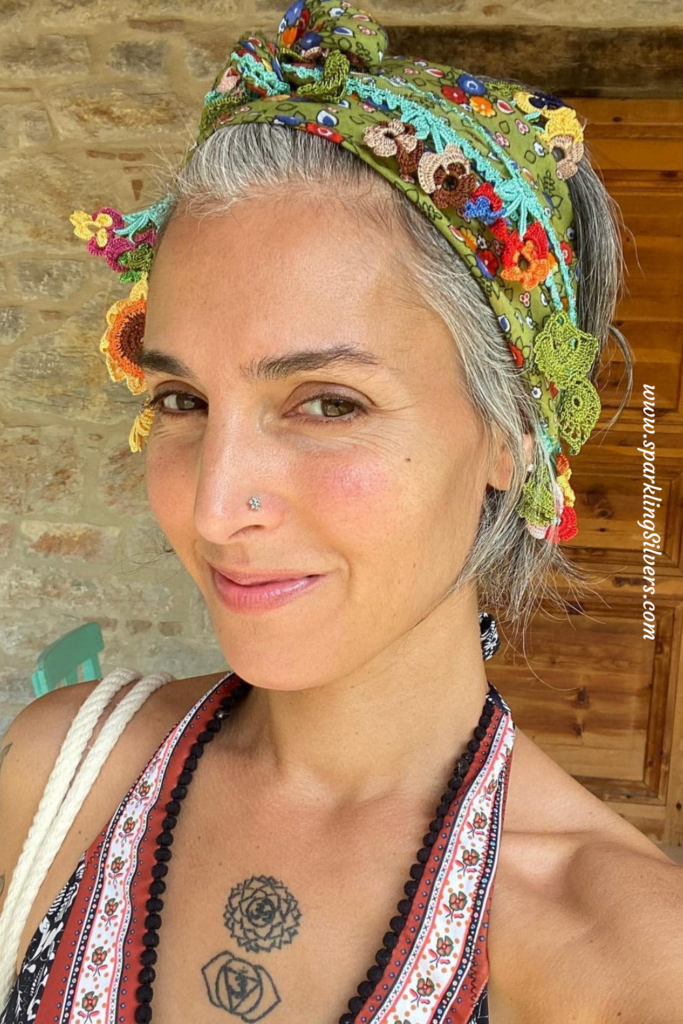 A young woman with grey hair and a scarf