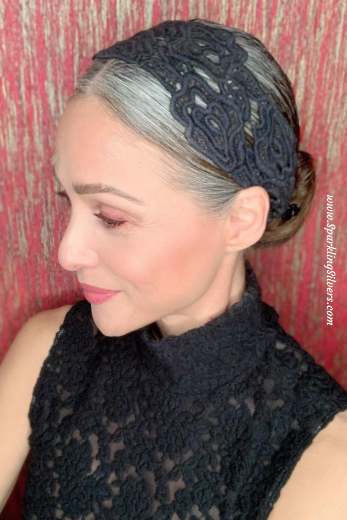 a white woman with gray hair, a black dress and a black headband