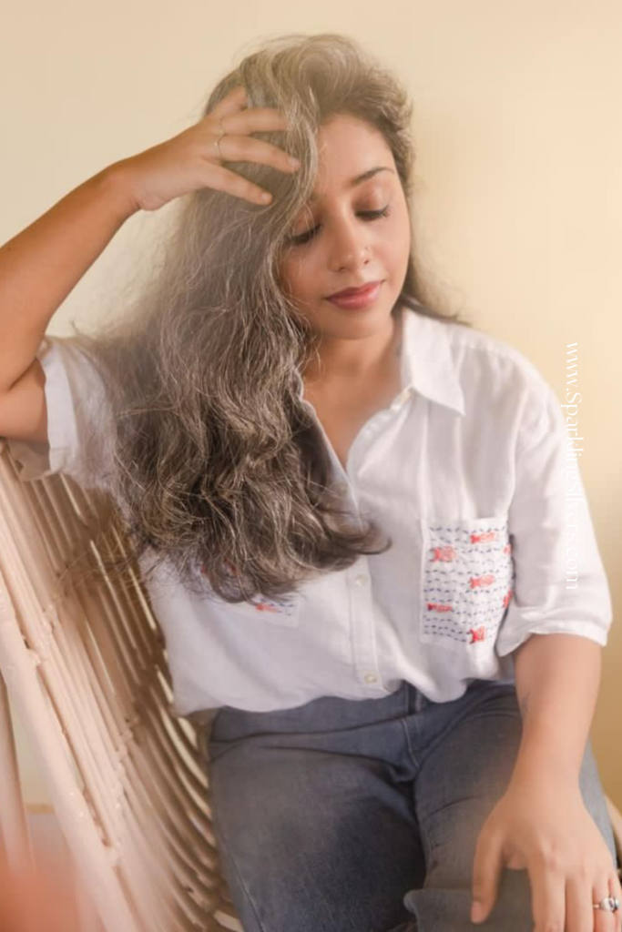 Picture of a woman with long silver hair and white shirt