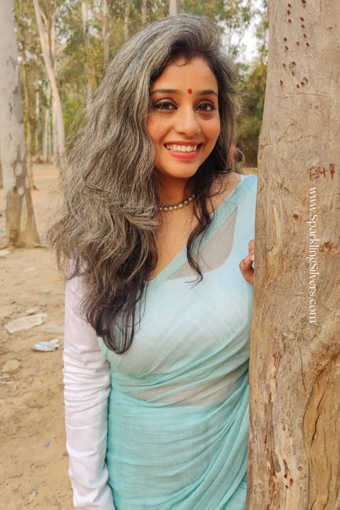 Picture of a young Indian woman with long wavy gray hair and a blue saree