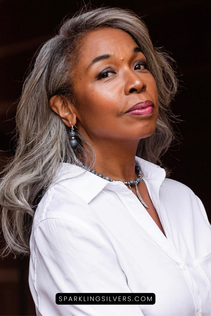 A cool toned woman with gray hair and white shirt