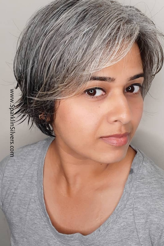A woman with short grey hair wearing a grey tshirt