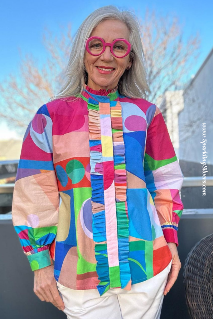 A Woman with white hair and a dress with abstract design.