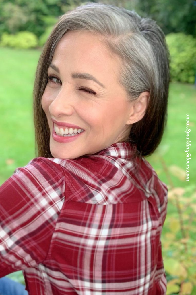 A woman with gray hair wearing plaids shirt.