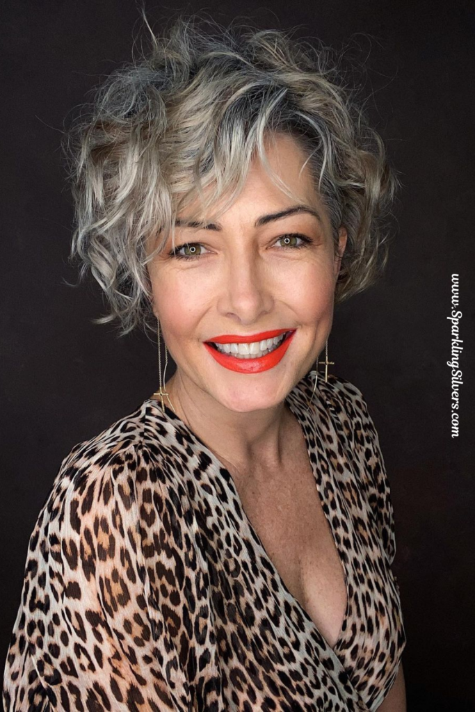 A woman with gray hair wearing a leopard print top.